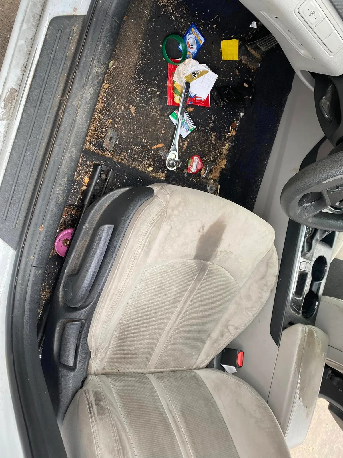 Dirty vehicle floor and driver area before professional interior detailing